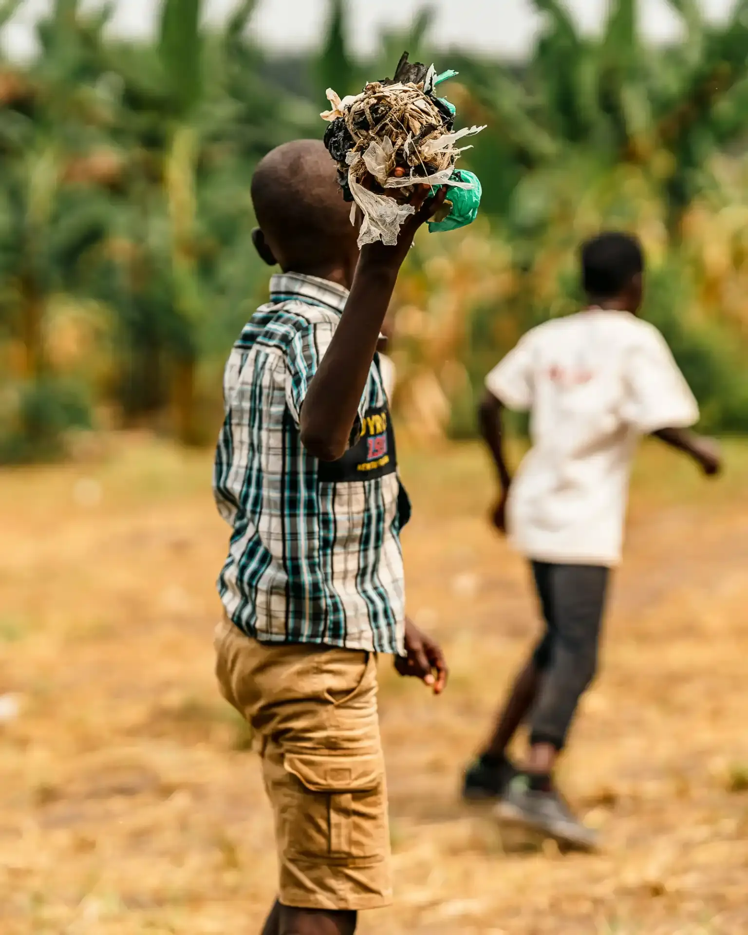 Child holding up handmade craft outdoors