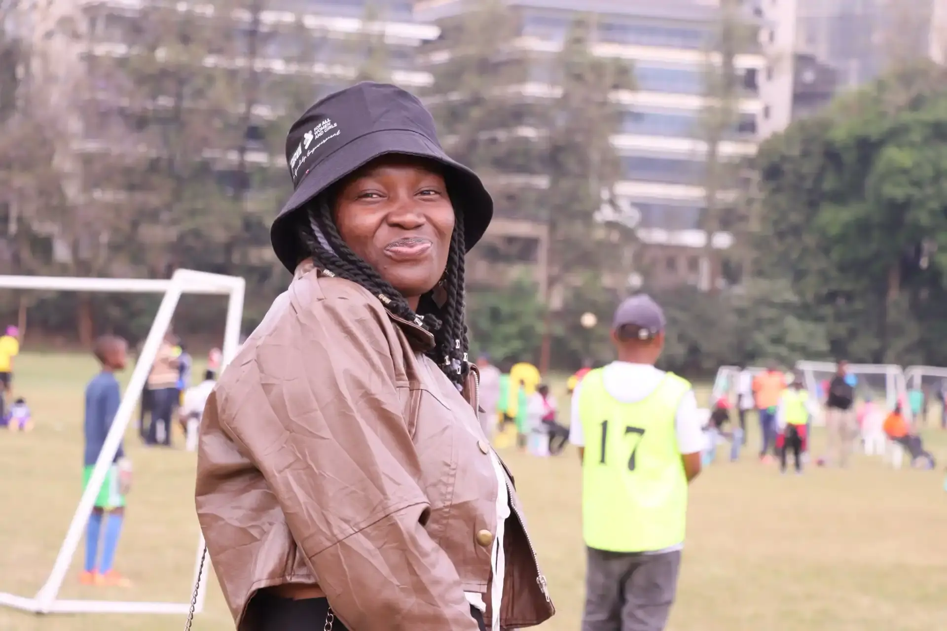 Woman in a bucket hat smiling on a field